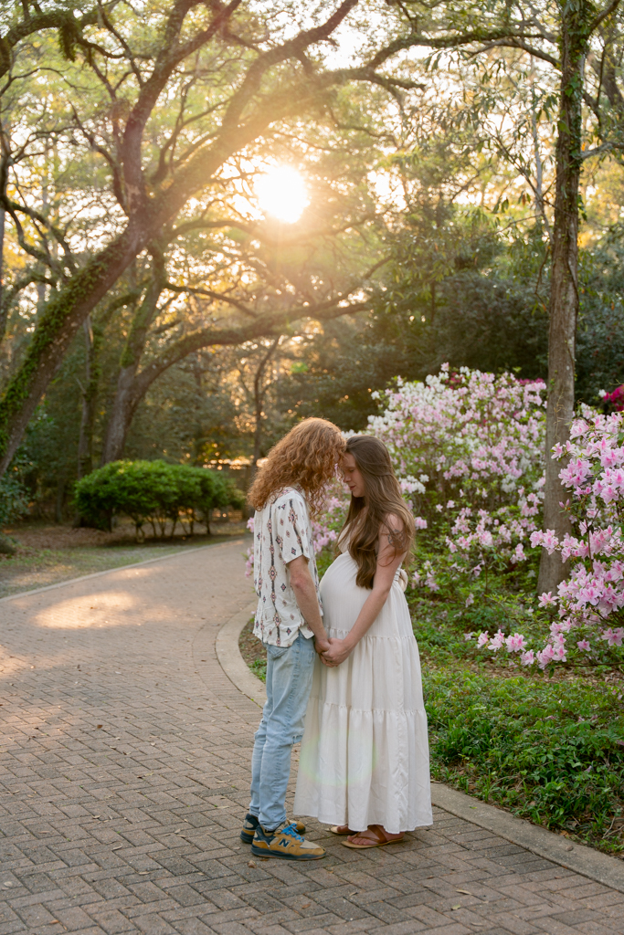 Couple sitting on a picnic blanket in the grass during a maternity session at Eden Gardens State Park.
