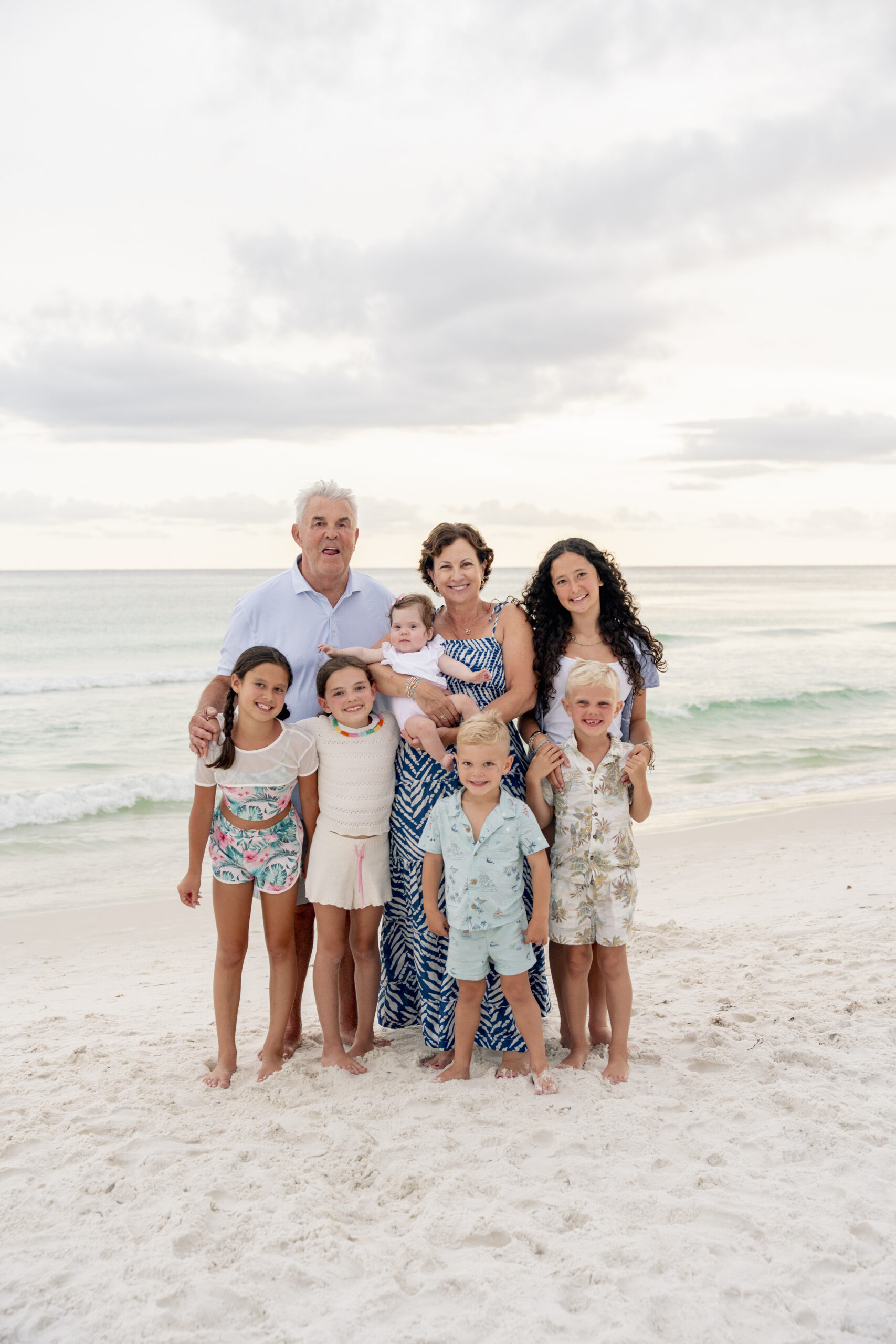 Large extended family standing together on the sand at Inlet Beach with dunes in the background.